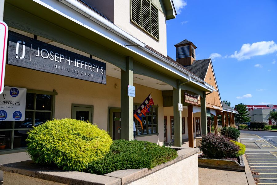 A row of shops including Joseph Jeffrey’s Hair Care Salon on a sunny day with clear blue skies.