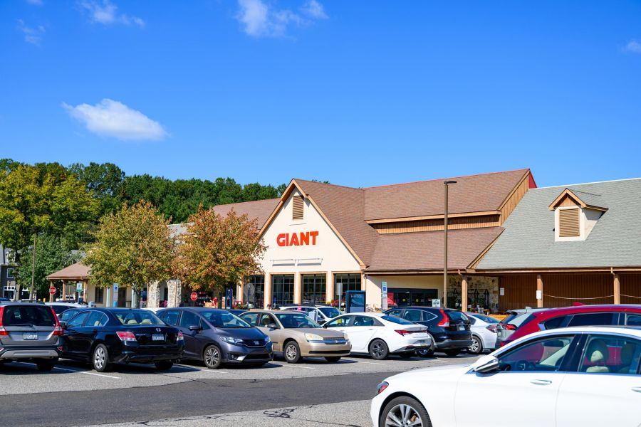 Parking lot filled with cars in front of a Giant grocery store on a sunny day.