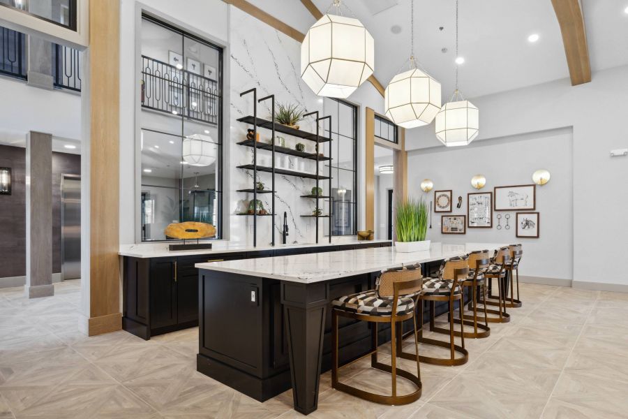 Modern kitchen with black island, marble countertops, bar stools, open shelving, and large pendant lights.