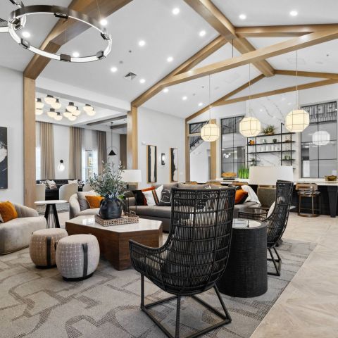 Modern lounge with cozy seating, large pendant lights, wooden beams, and contemporary decor.